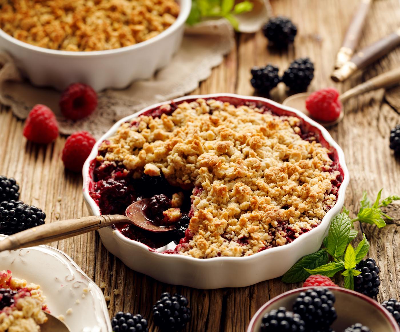 Beeren Crumble angerichtet mit Früchten und frischer Minze