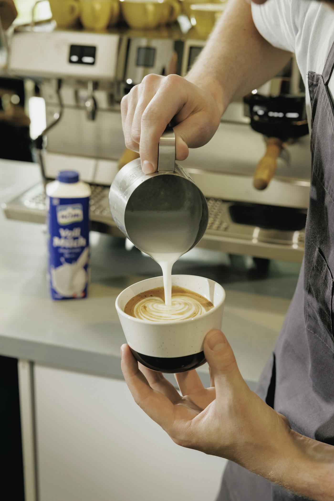 Barista beim Milch aufschäumen für Latte Art