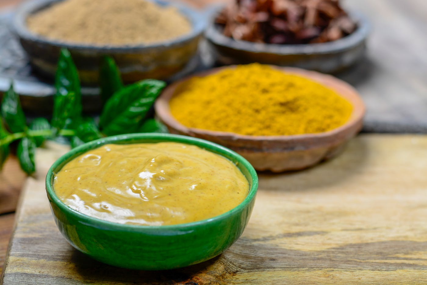 Köstliche Curry-Sauce in einer kleinen Schüssel, servierfertig, mit Mangos und Currypulver