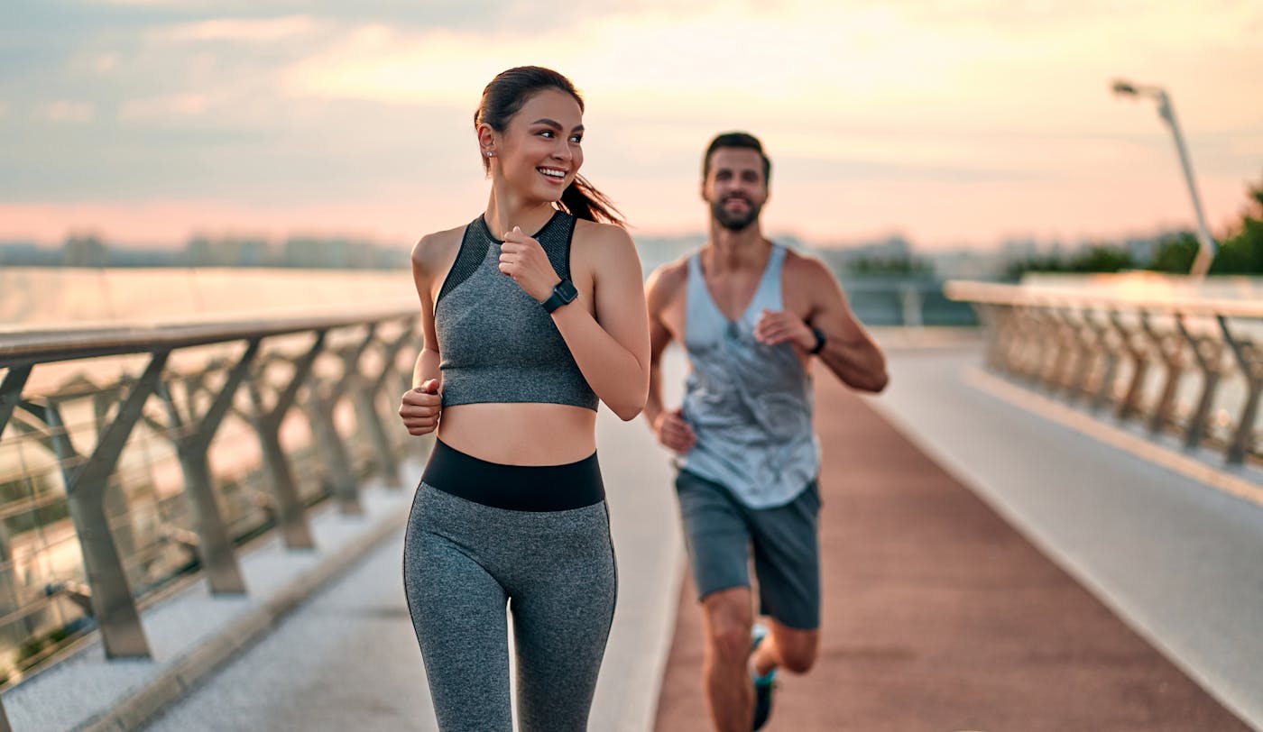 Sportliches Paar läuft über Brücke