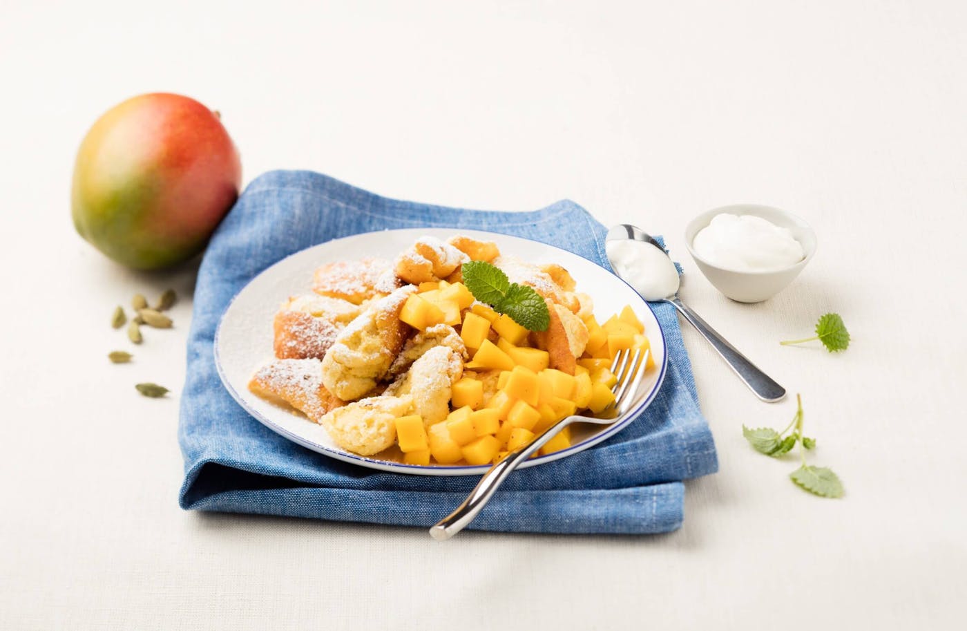 Teller mit Kaiserschmarrn und Mango Eine köstliche Kombination aus Kaiserschmarrn und Mango.