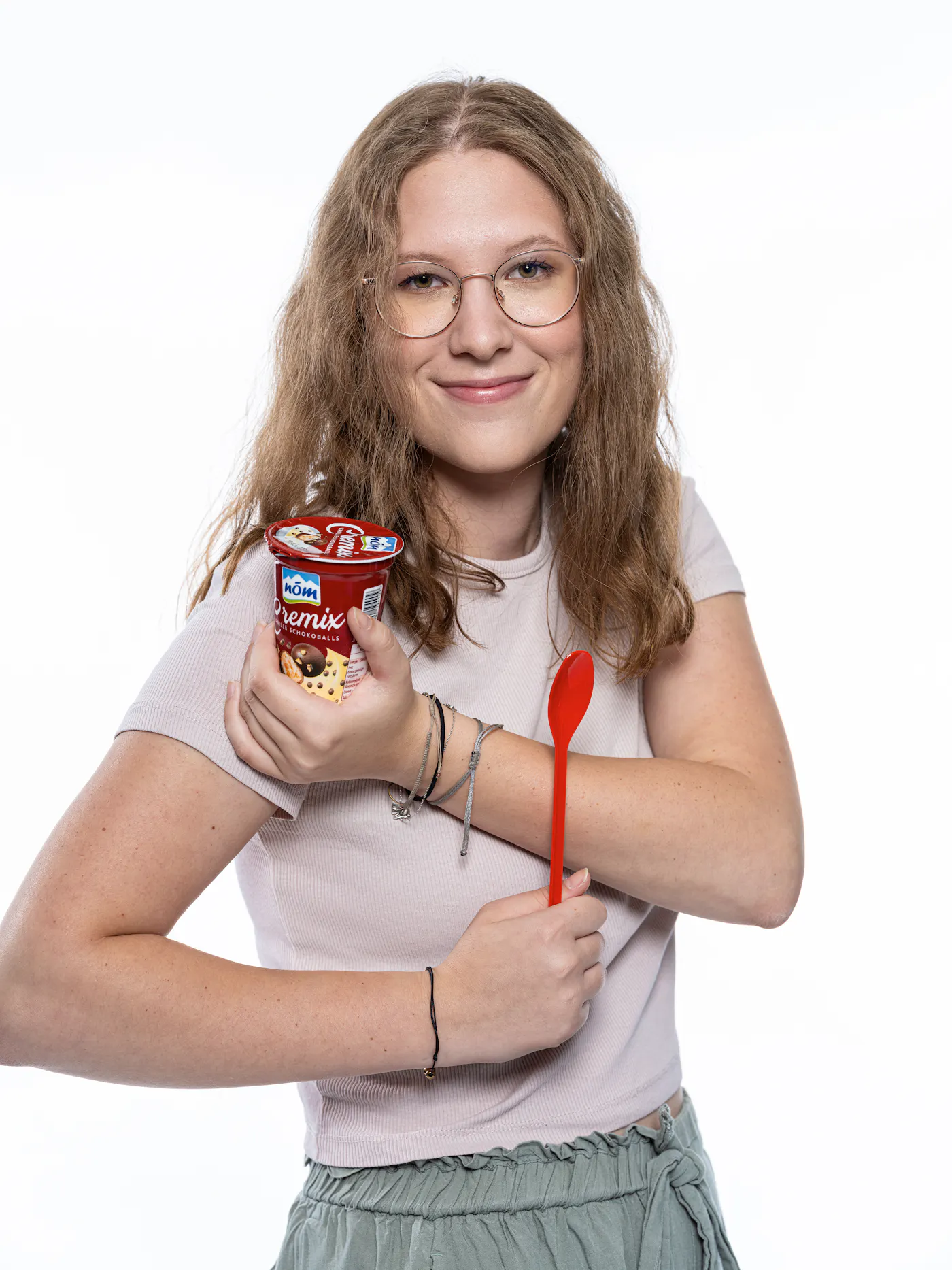 Mitarbeiterin der NÖM mit einem Becher Cremix und einem Löffel in der Hand
