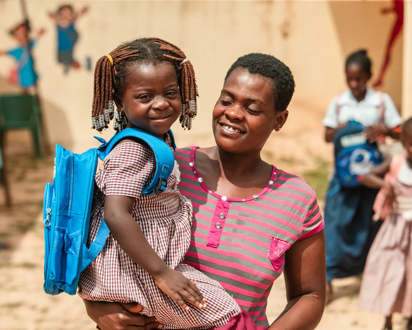 c Fairtrade Africa Mutter mit Tochter und Schulrucksack