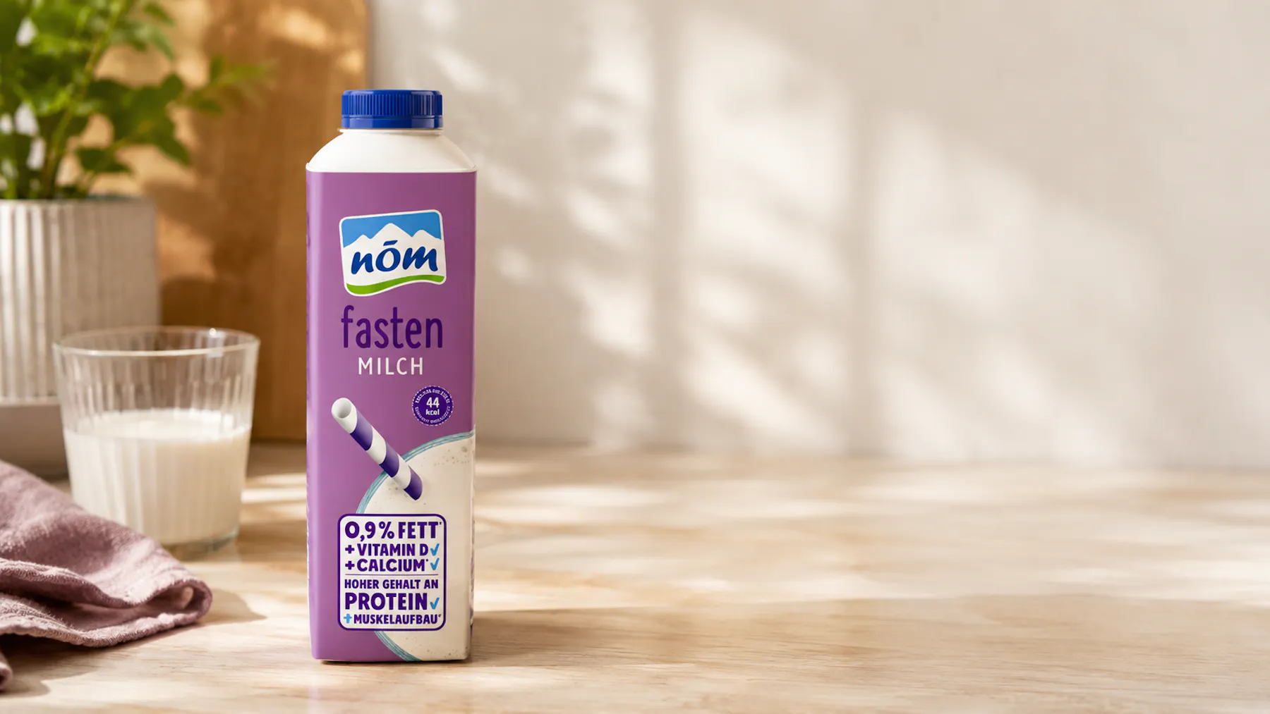 NÖM fasten Milch-Packung mit einem Glas Milch im Hintergrund