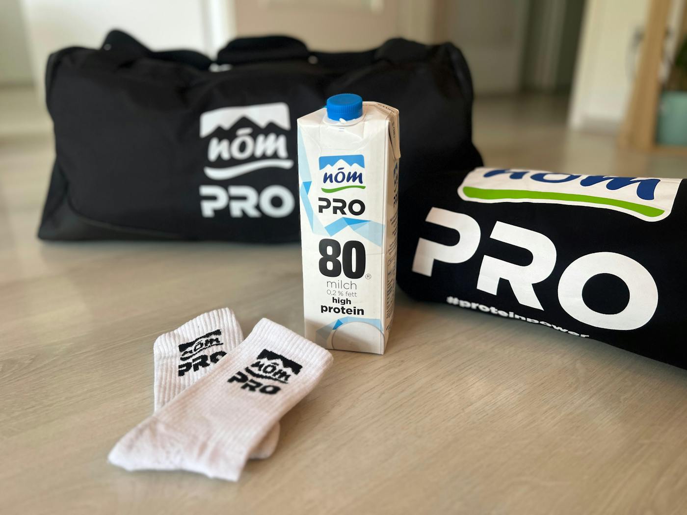 NÖM PRO Milch mit PRO Socken, einer PRO Sporttasche und einem PRO Hoodie