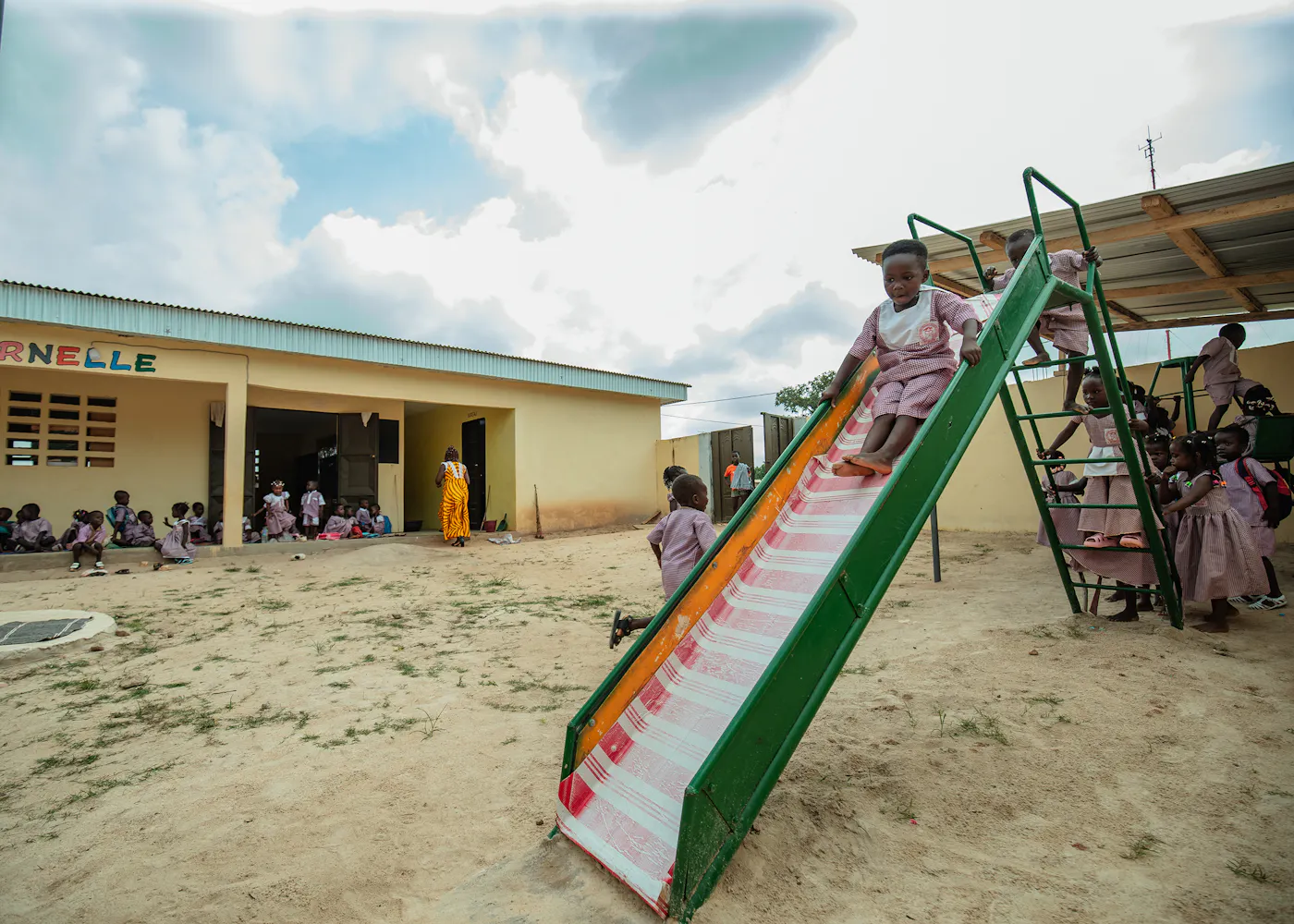 Schulhof mit Kindern und einer Rutsche