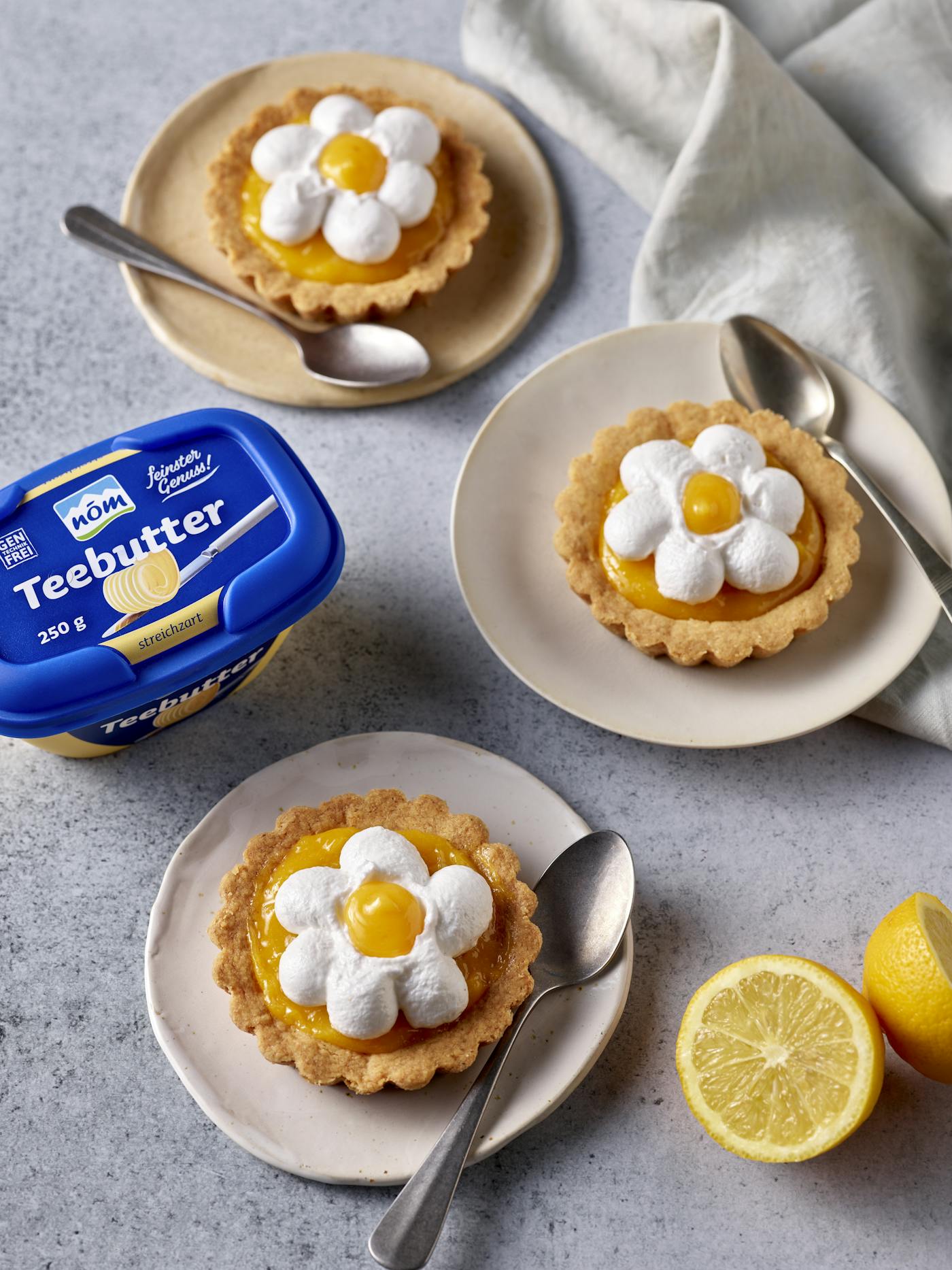 Zitronentoertchen angerichtet mit Zitronen und NÖM Teebutter Zitronentoertchen angerichtet mit Zitronen und NÖM Teebutter