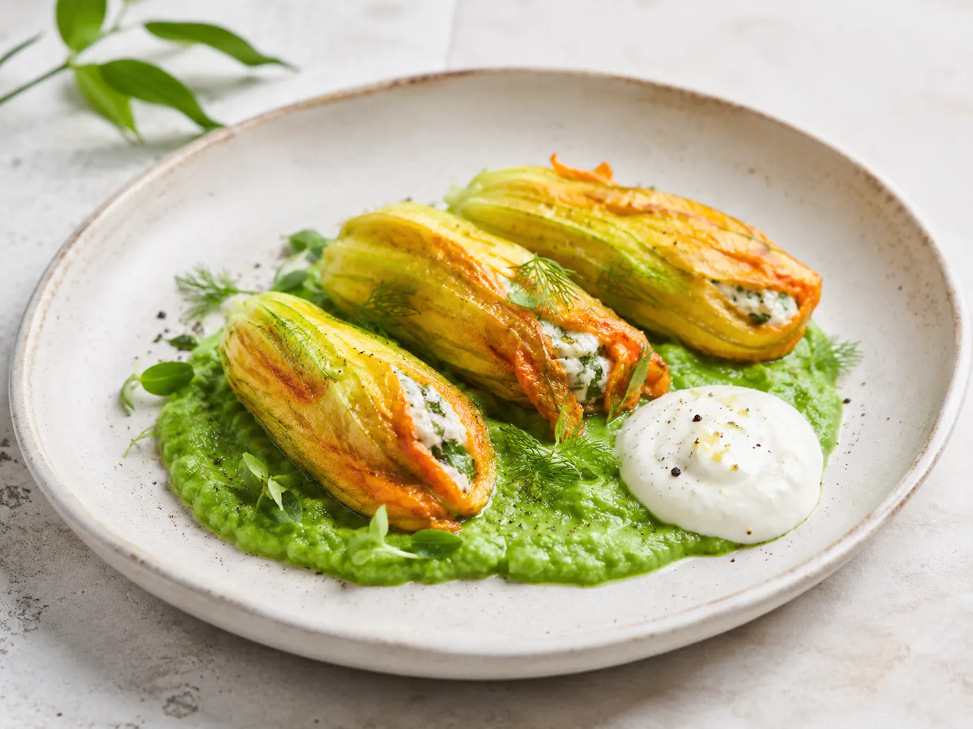 gefüllte Zucchiniblüten auf Erbsenpüree