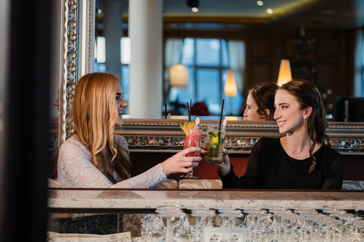 Zwei Freundinnen drinken Cocktails in einer Bar