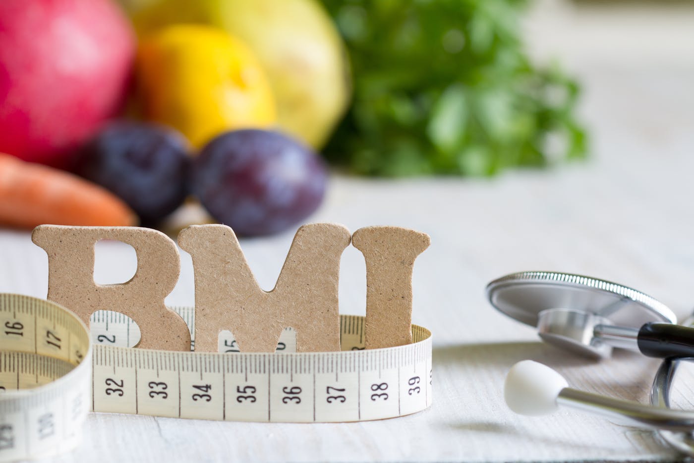 Body-Mass-Index Schriftzug vor Obst und Salat
