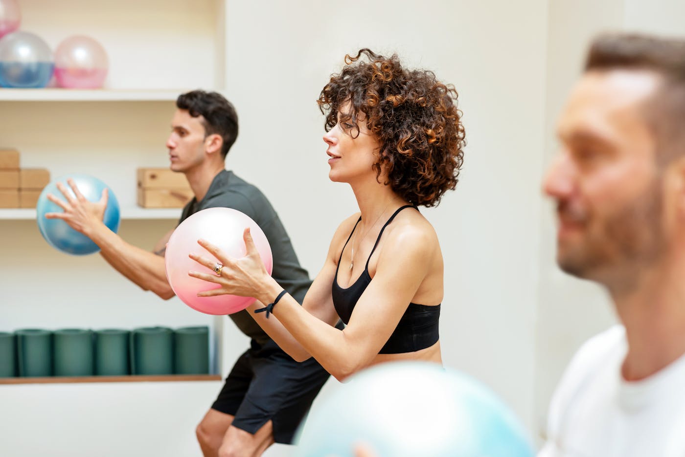Eine Gruppe fitter Menschen macht funktionelles Krafttraining mit kleinem Gymnastikball