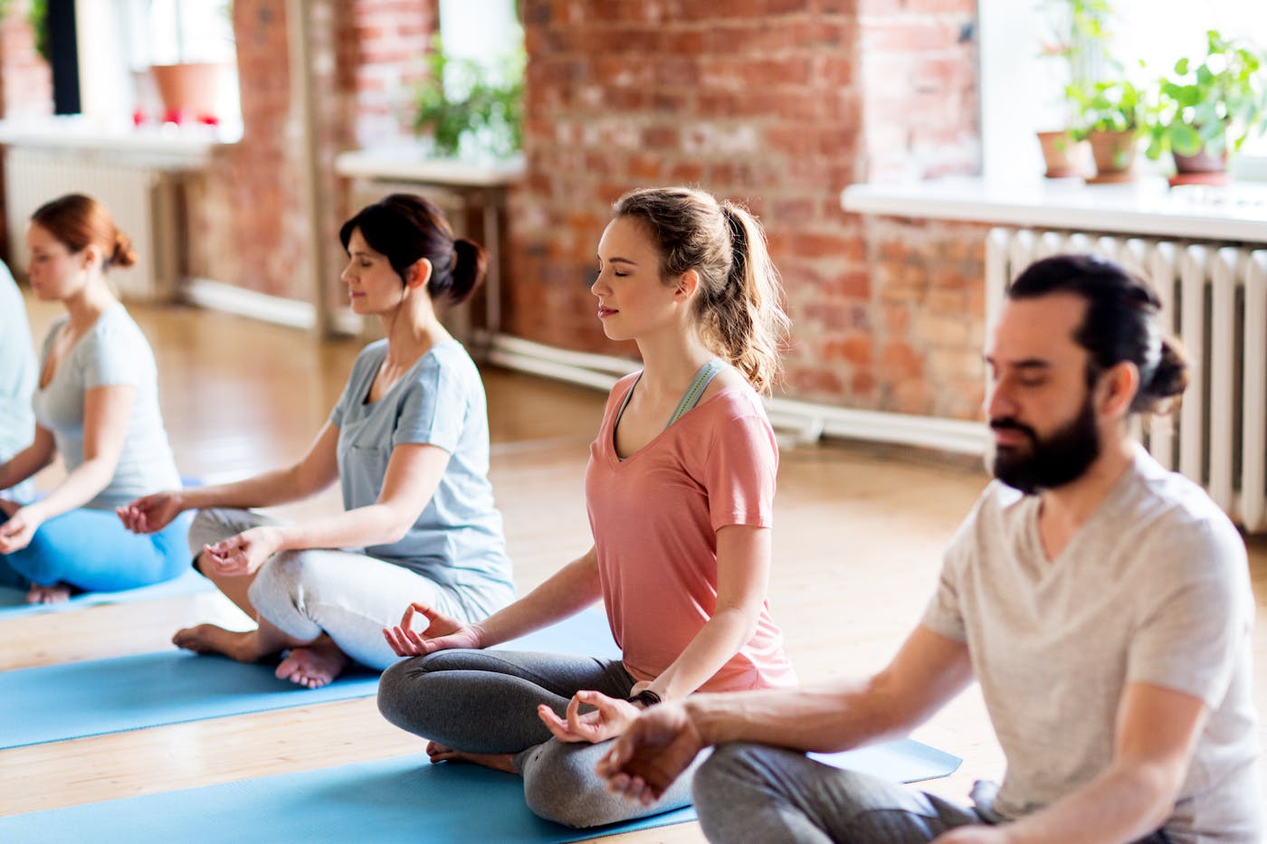 Gruppe von Yogis praktiziert Yoga auf Matten im Studio