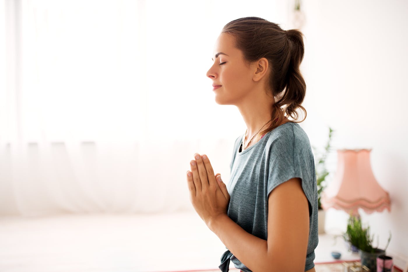 Junge Frau meditiert im Yogastudio