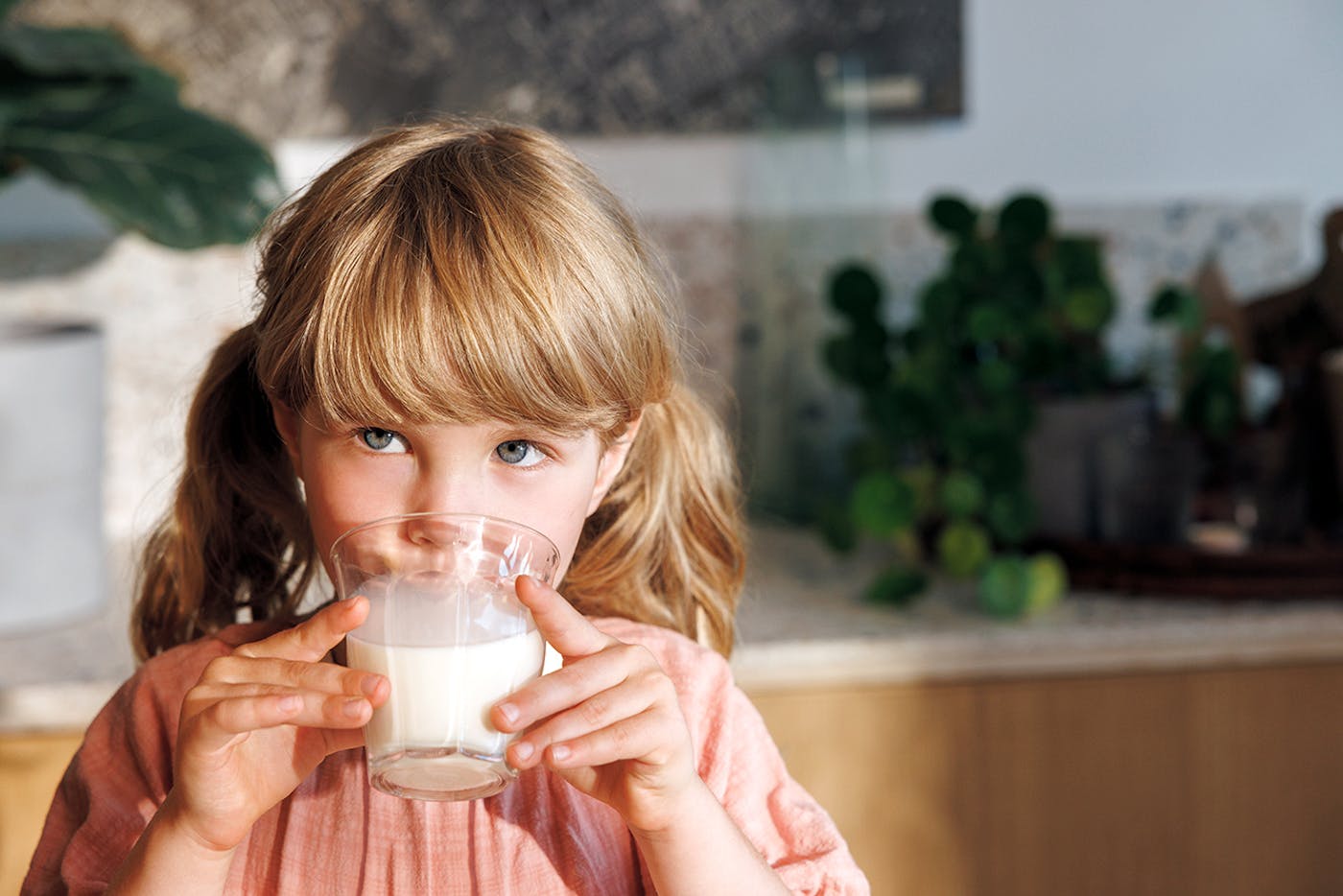 Mädchen deckt ihren Proteinbedarf mit einem Glas Milch
