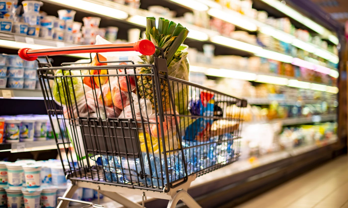 Ein Einkaufswagen voller Lebensmittel steht im Supermarkt