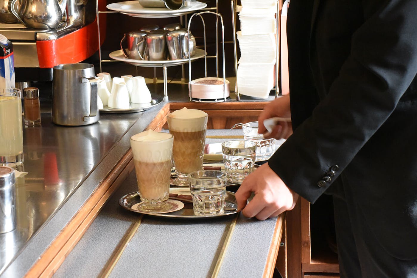 Ober in Wiener Kaffeehaus bereitet Milchkaffe in Küche zu