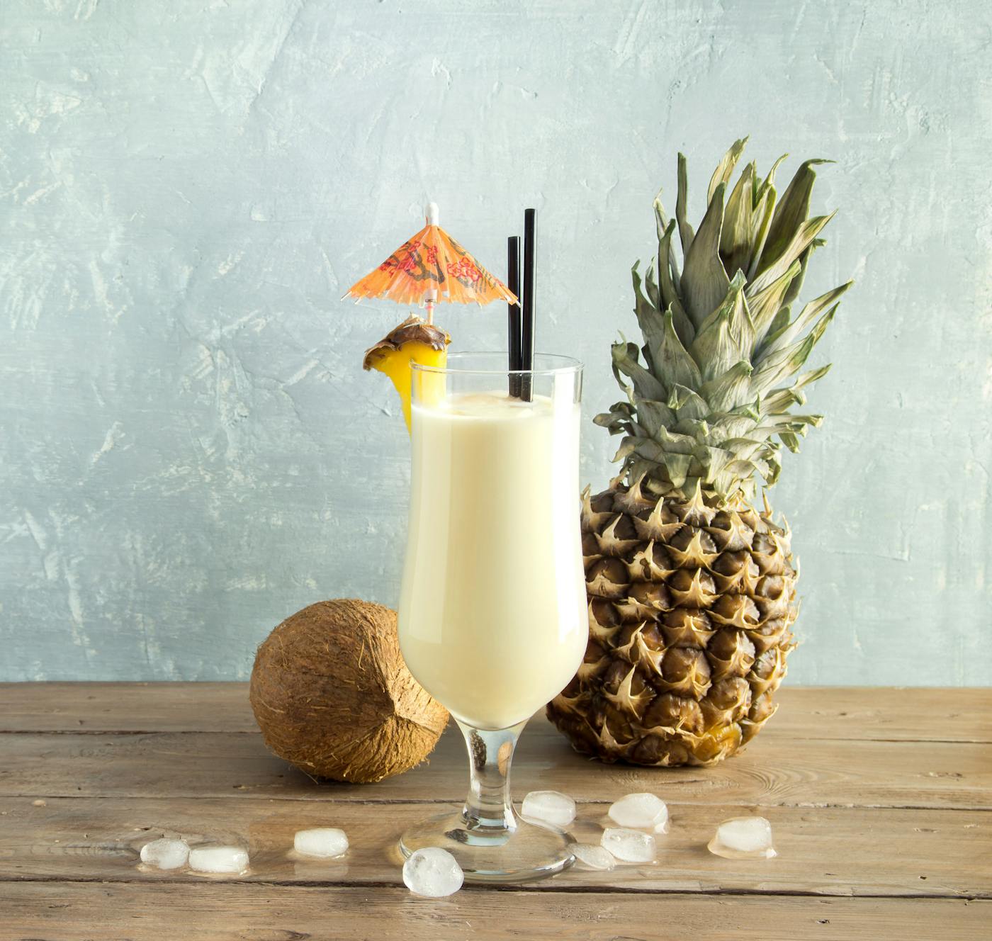 Pina Colada Cocktail - Tropische Erfrischung mit Ananas und Kokosnuss in einem Glas auf Holztisch.