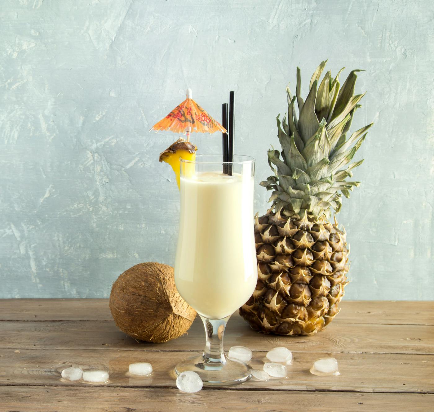 Pina Colada Cocktail - Tropische Erfrischung mit Ananas und Kokosnuss in einem Glas auf Holztisch.