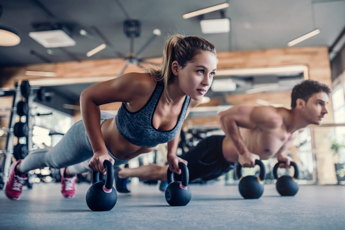 Sportliches Paar trainiert mit Kettlebells im Fitnessstudio